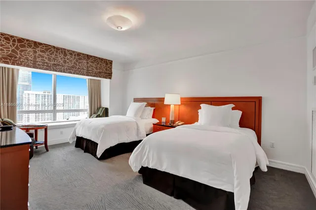 a bedroom with two beds and a large window