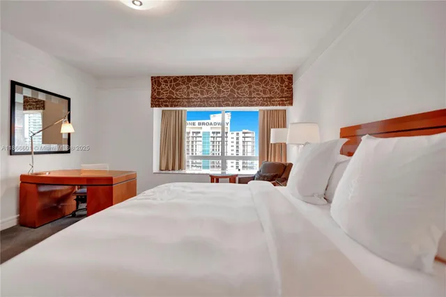 a bedroom with a bed and a dresser next to a window