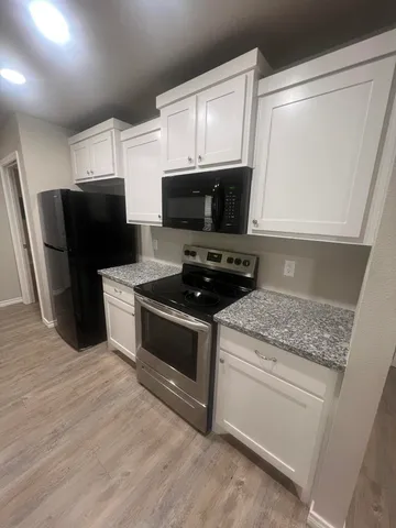 a kitchen with stainless steel appliances a stove a microwave a sink and cabinets