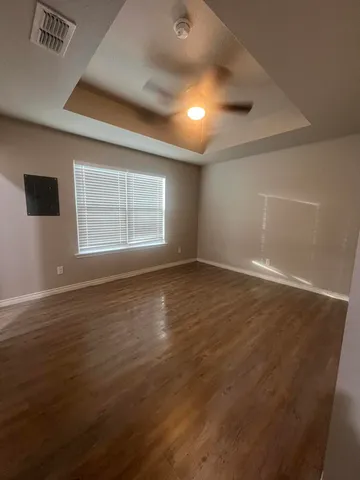 an empty room with wooden floor and windows