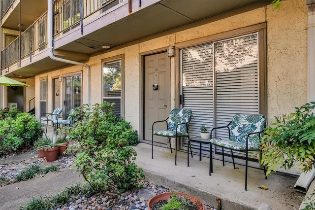 a patio with table and chairs and potted plants