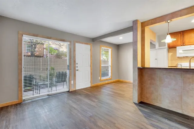 a view of a kitchen with wooden floor and a window