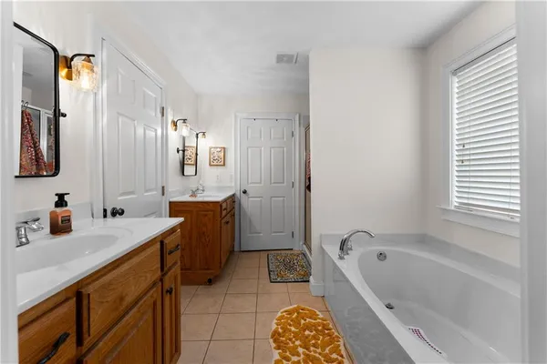 a bathroom with a tub sink and mirror