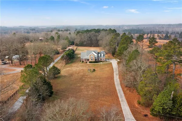 an aerial view of a house with a yard and lake view