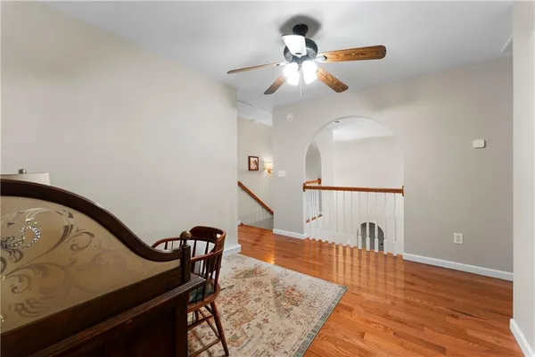 a view of a hallway with wooden floor and stairs