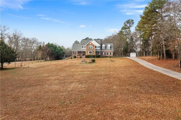 a view of an house with backyard and trees