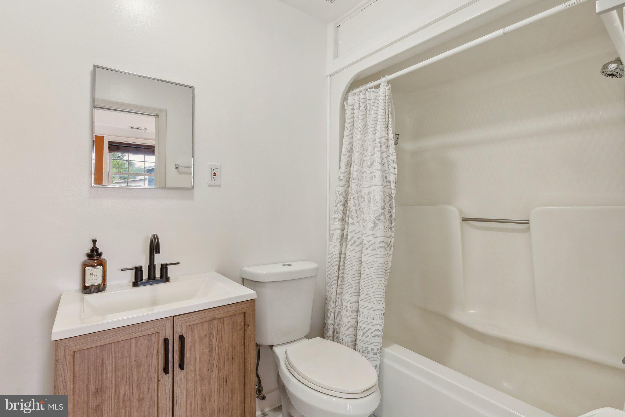 5207 Eugene Avenue Baltimore, MD 21206 - Photo 13 of 36 a bathroom with a sink a toilet and shower