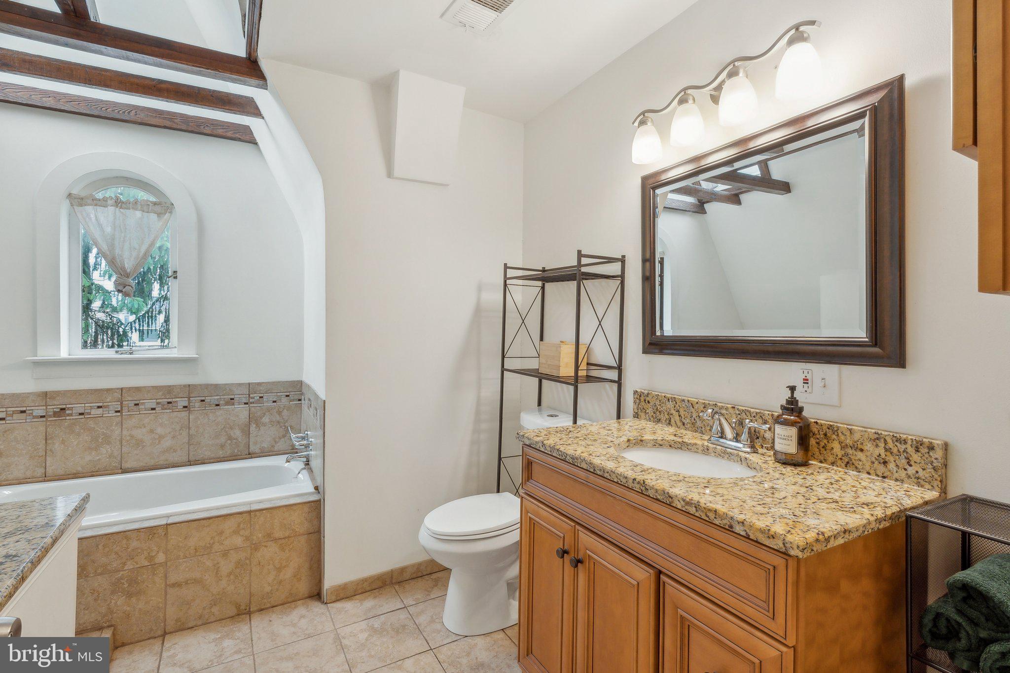 5207 Eugene Avenue Baltimore, MD 21206 - Photo 19 of 36 a bathroom with a granite countertop bathtub sink vanity mirror and toilet