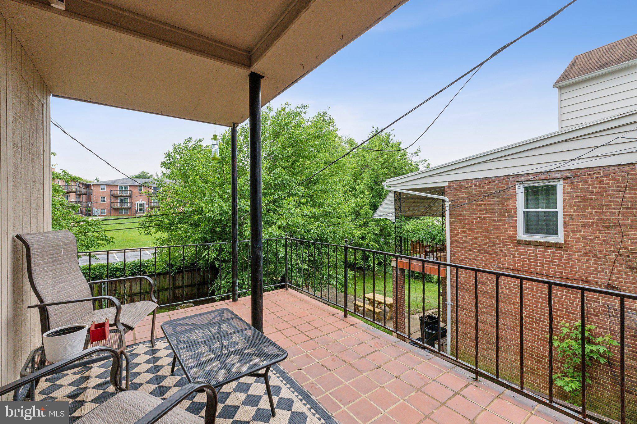 5207 Eugene Avenue Baltimore, MD 21206 - Photo 28 of 36 a view of a patio with table and chairs potted plants with wooden floor and fence