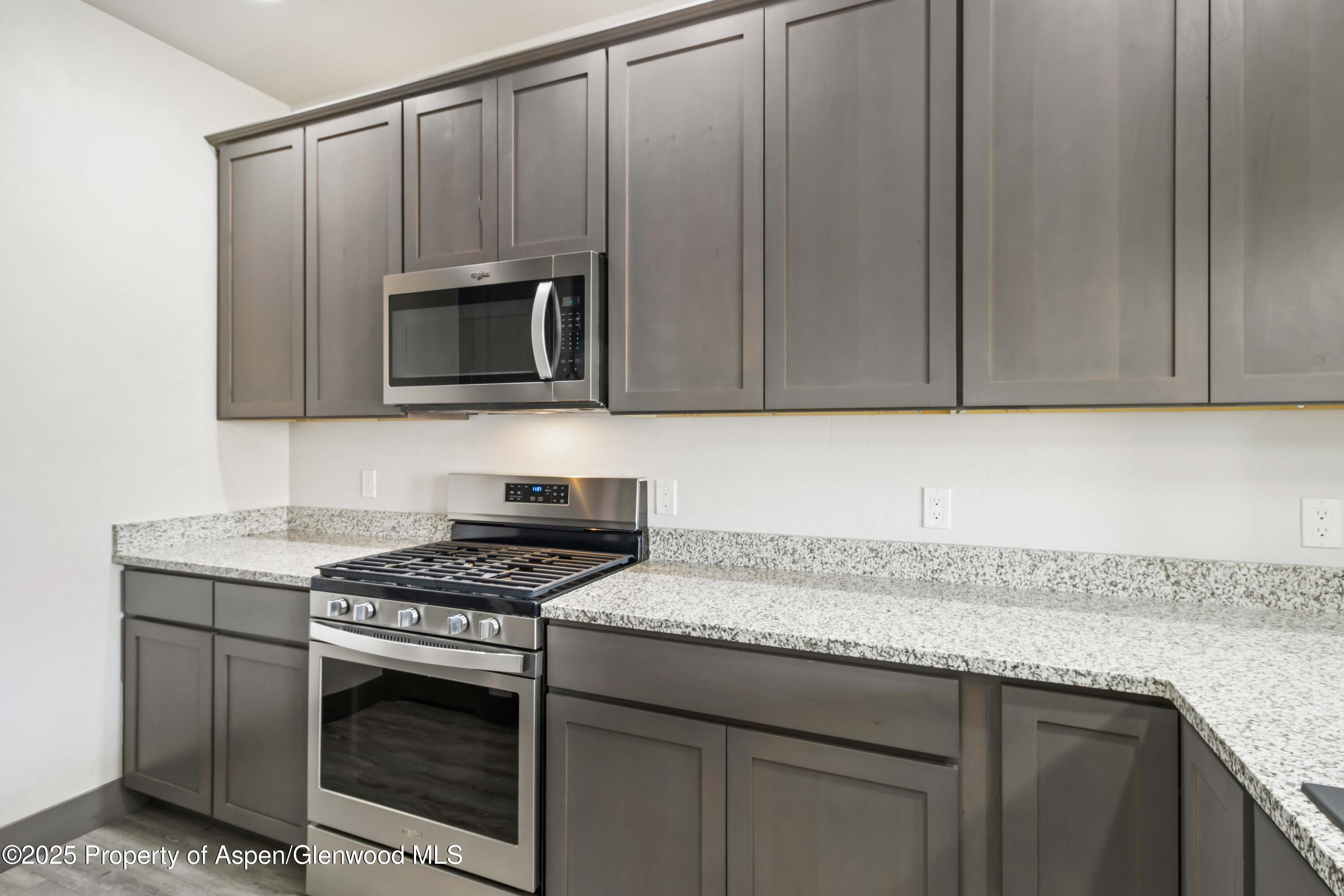 123 Redstone Drive New Castle, CO 81647 - Photo 23 of 34 a kitchen with granite countertop cabinets stove and microwave