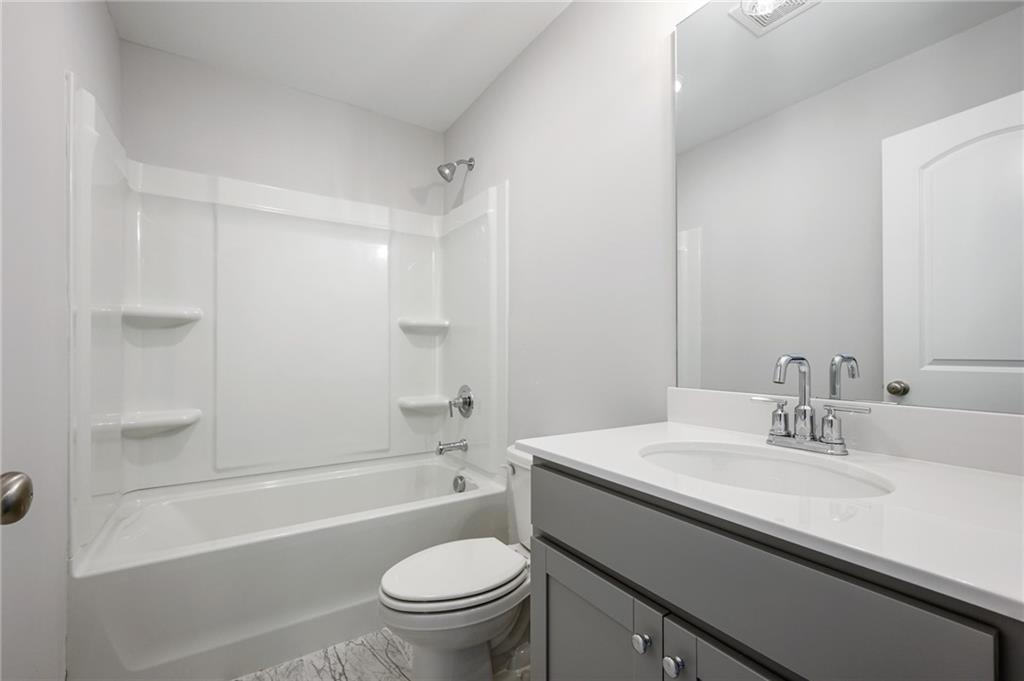 3744 Silvery Way Powder Springs, GA 30127 - Photo 16 of 26 a bathroom with a sink a toilet and shower