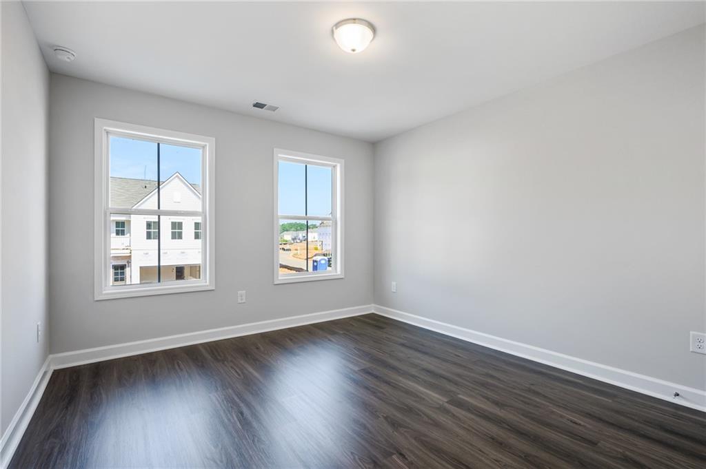 3744 Silvery Way Powder Springs, GA 30127 - Photo 17 of 26 an empty room with wooden floor and windows