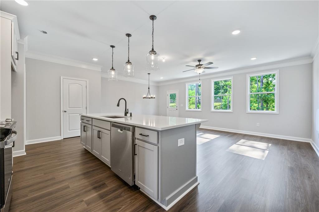 3744 Silvery Way Powder Springs, GA 30127 - Photo 4 of 26 a large kitchen with stainless steel appliances a large counter top a sink a refrigerator and a window
