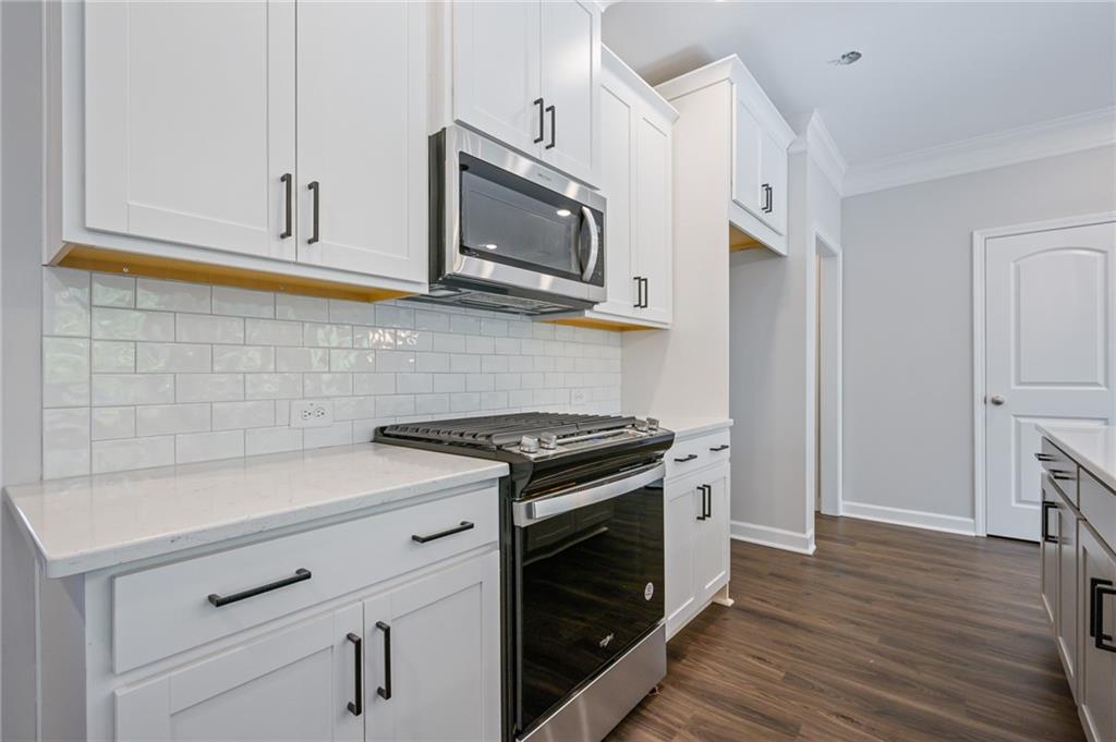 3744 Silvery Way Powder Springs, GA 30127 - Photo 5 of 26 a kitchen with stainless steel appliances white cabinets and a stove top oven