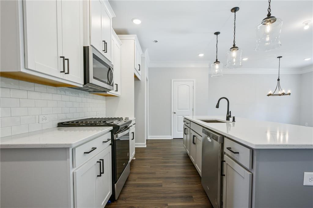 3744 Silvery Way Powder Springs, GA 30127 - Photo 6 of 26 a kitchen with stainless steel appliances a sink stove top oven and cabinets