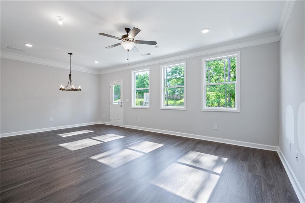 3744 Silvery Way Powder Springs, GA 30127 - Photo 9 of 26 a view of an empty room with wooden floor and a window