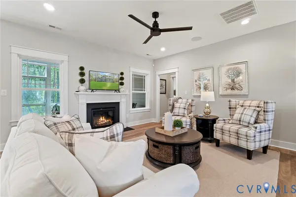a living room with furniture a fireplace and a large window