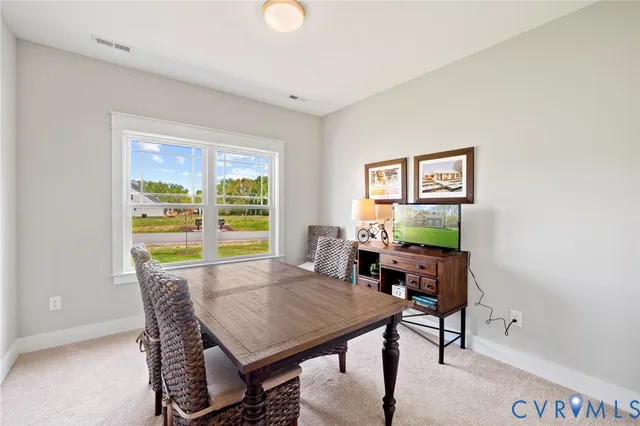 a view of a dining room with furniture a rug and wooden floor