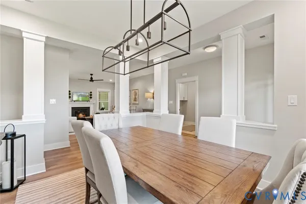 a view of a dining room and livingroom with furniture wooden floor a chandelier