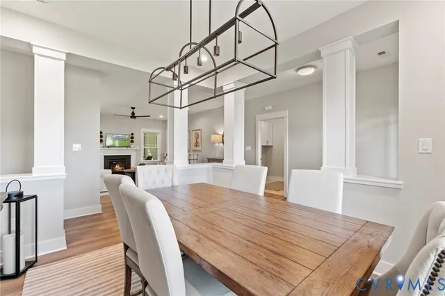 a view of a dining room and livingroom with furniture wooden floor a chandelier