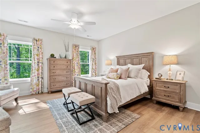 a spacious bedroom with a bed a couch and dresser