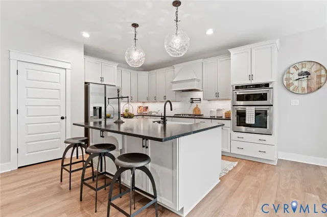 a kitchen with stainless steel appliances a stove a refrigerator and a microwave