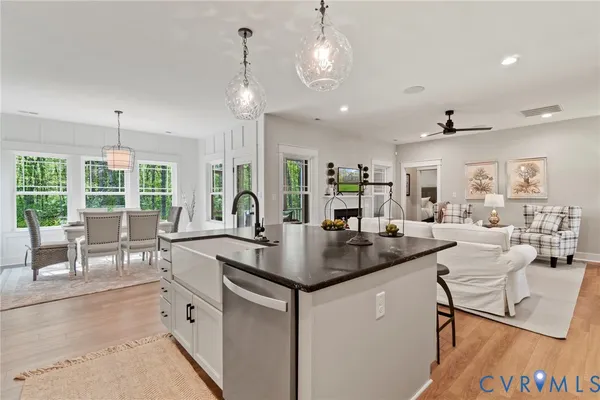 a view of center island of a kitchen with granite countertop living room and living room