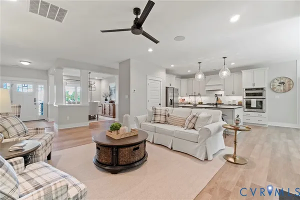 a living room with furniture and a view of kitchen