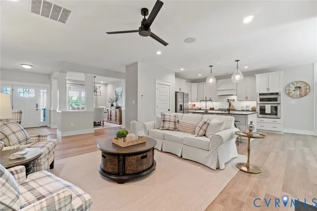 a living room with furniture and a view of kitchen
