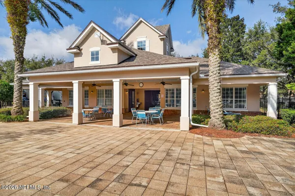 a view of a house with a yard and palm trees