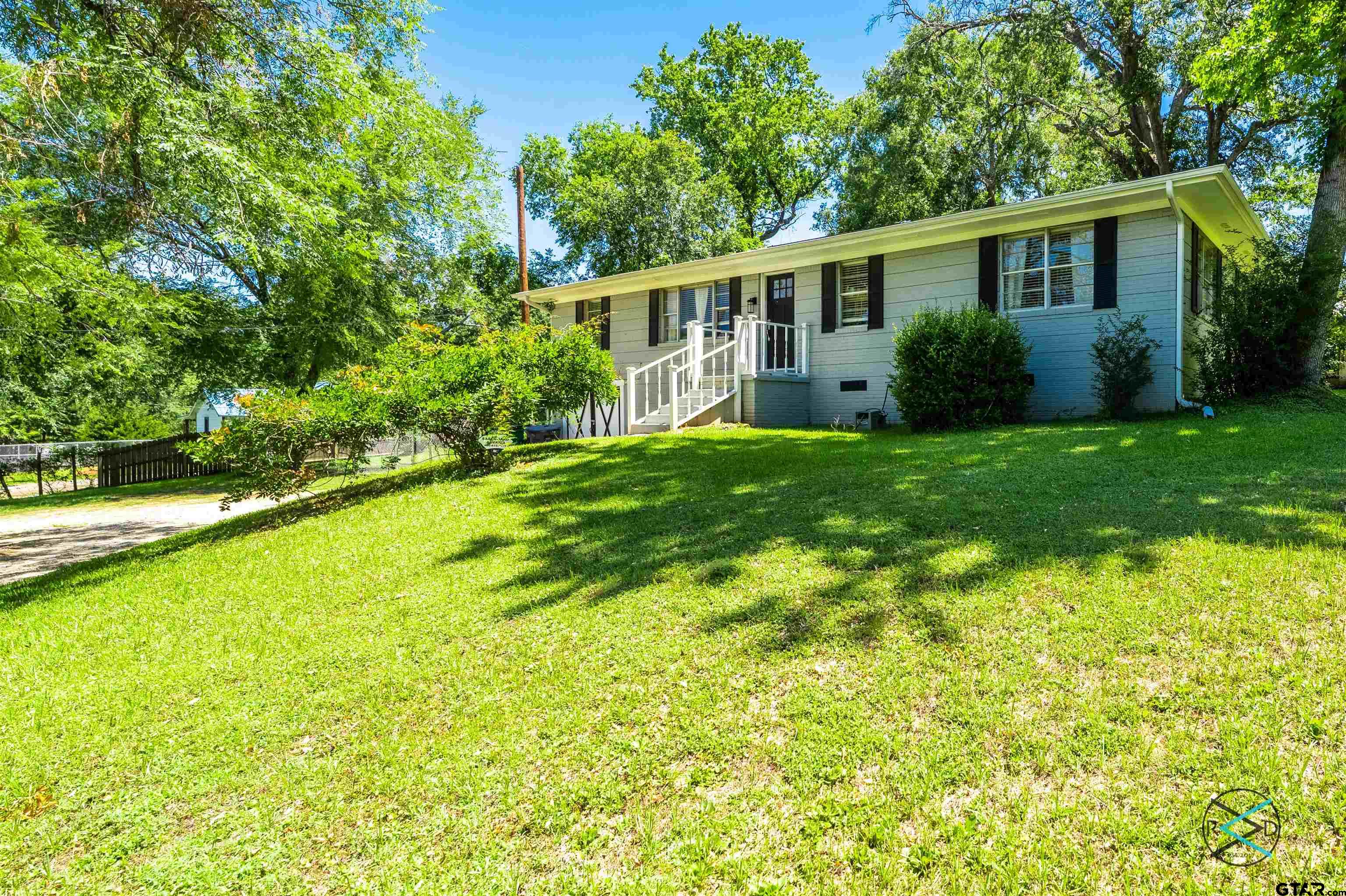 a view of house with backyard and a garden