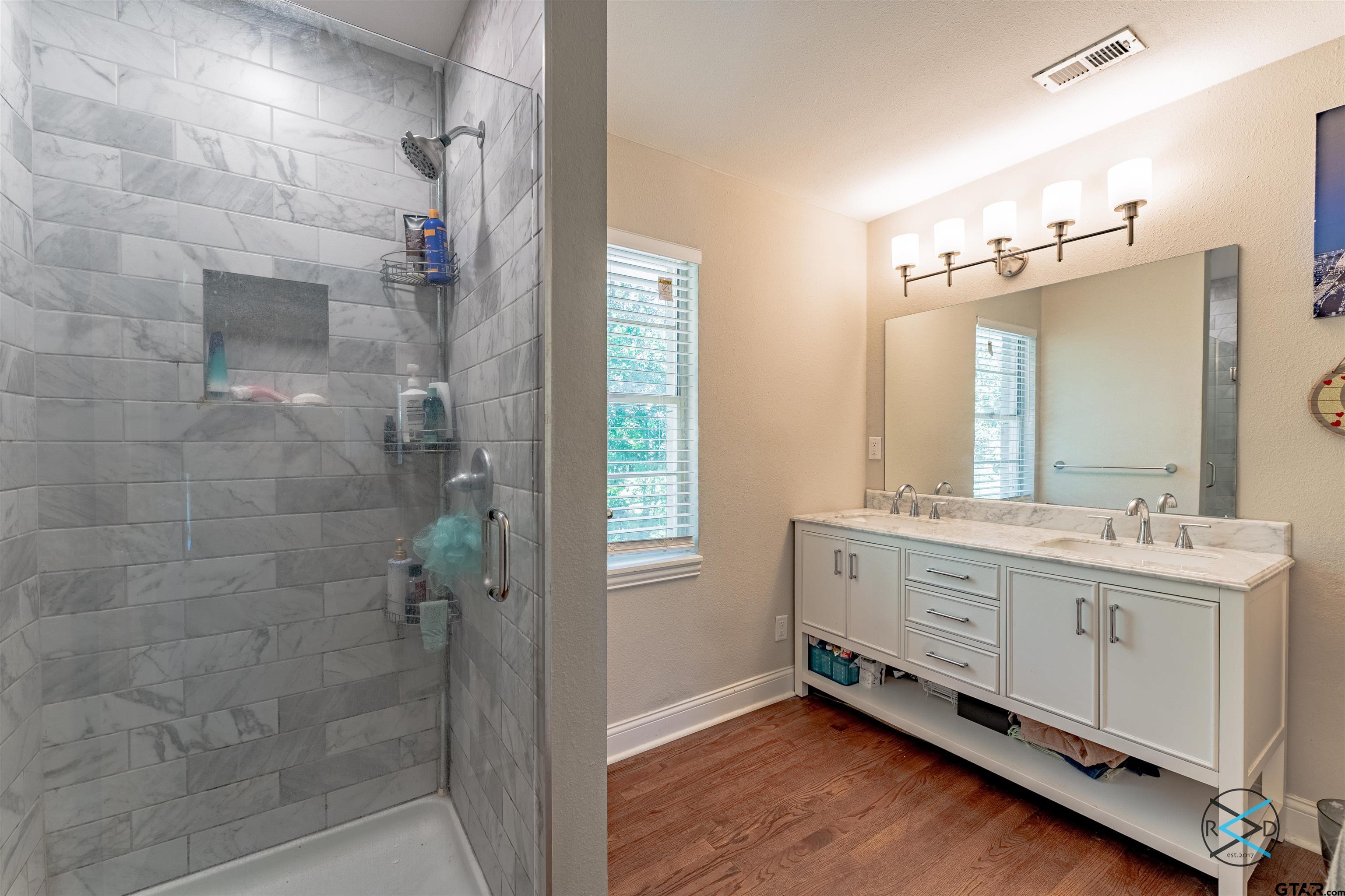 1506 Bassett Road Palestine, TX 75803 - Photo 11 of 18 a bathroom with a double vanity sink a mirror and a shower