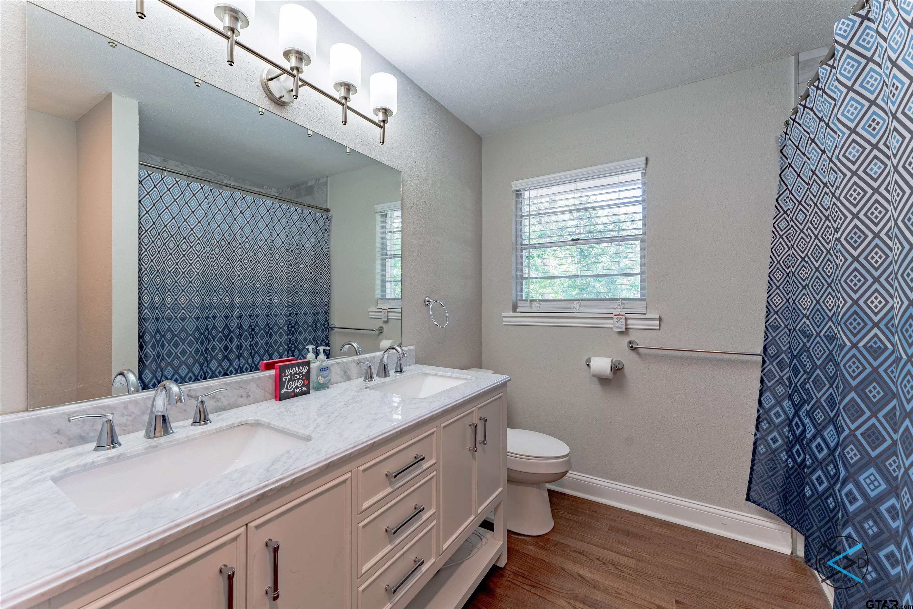 1506 Bassett Road Palestine, TX 75803 - Photo 12 of 18 a bathroom with a double vanity sink toilet and a mirror
