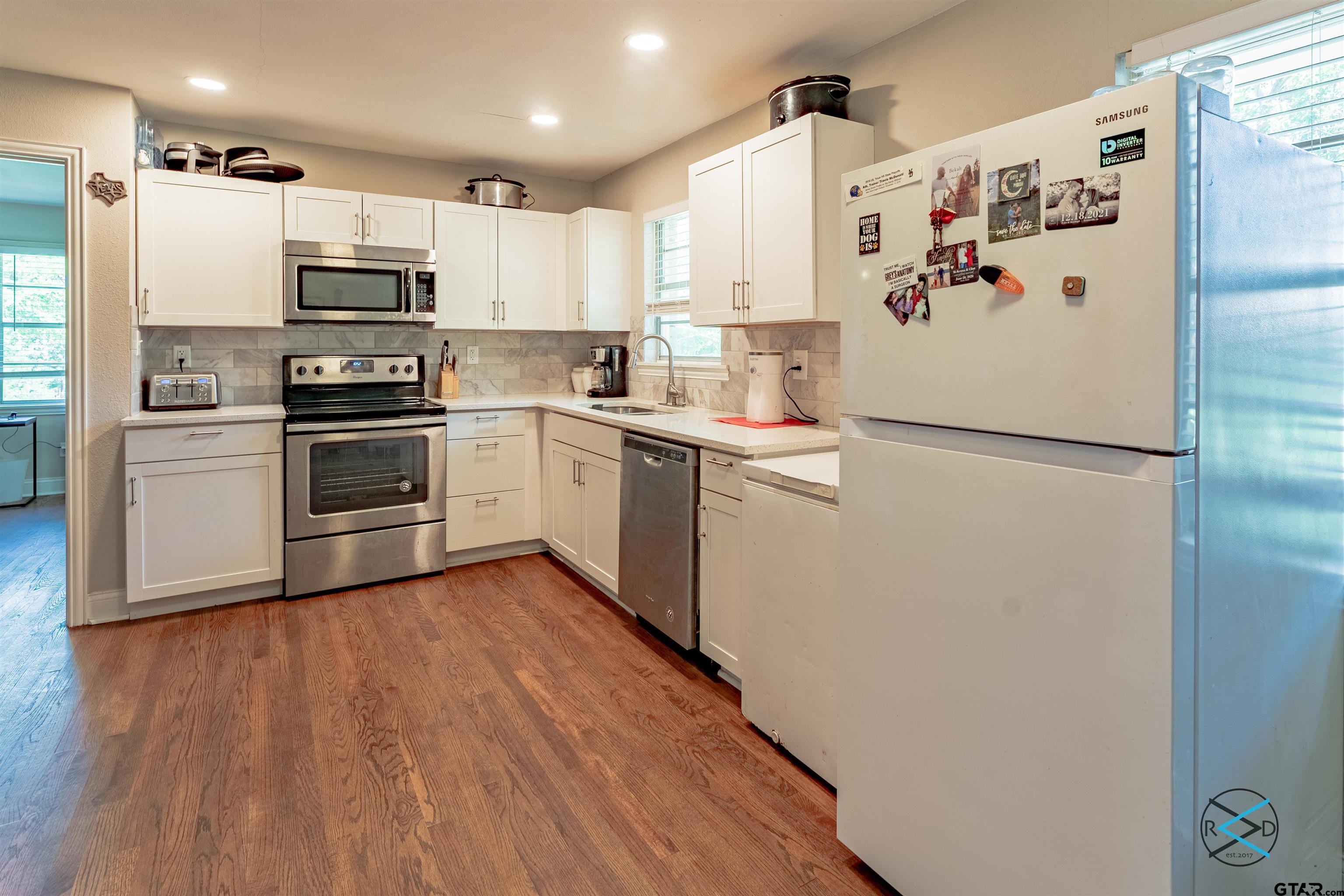 1506 Bassett Road Palestine, TX 75803 - Photo 6 of 18 a kitchen with cabinets stainless steel appliances and wooden floor