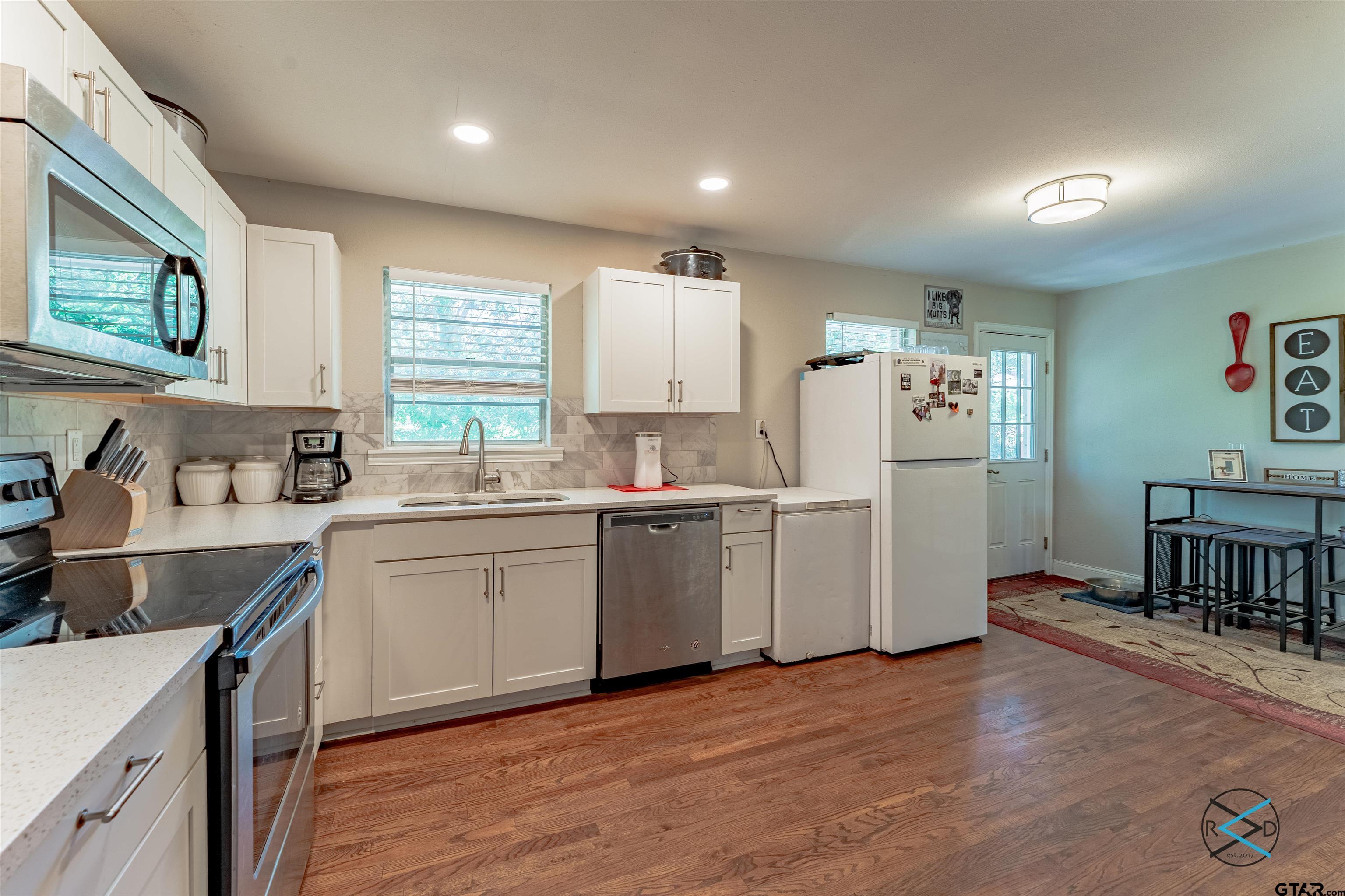 1506 Bassett Road Palestine, TX 75803 - Photo 7 of 18 a kitchen with refrigerator cabinets and wooden floor