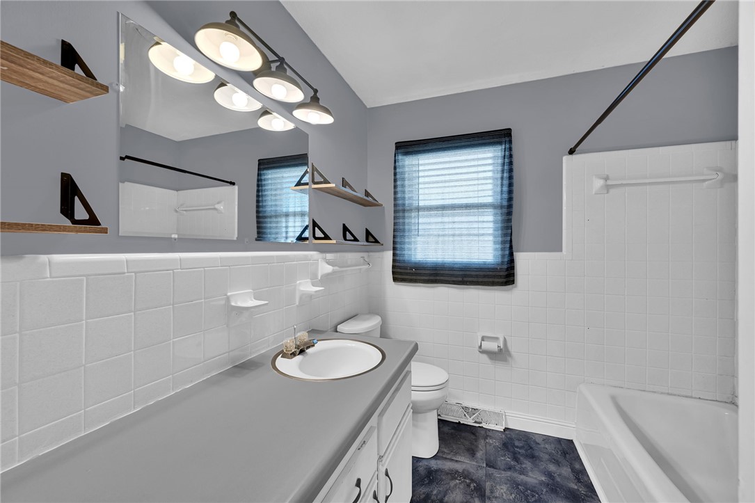 121 Wilson Road Anderson, SC 29625 - Photo 22 of 40 Classic tile wainscoting and a modern vanity define this updated bathroom space.