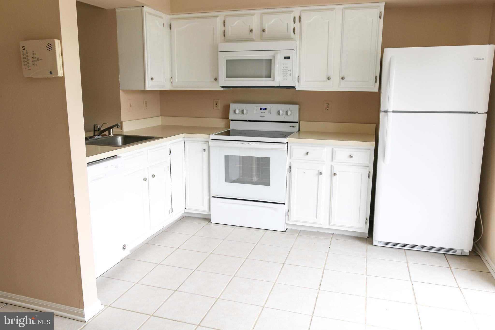 2212 Riding Crop Way Baltimore, MD 21244 - Photo 4 of 19 a kitchen with cabinets and white appliances