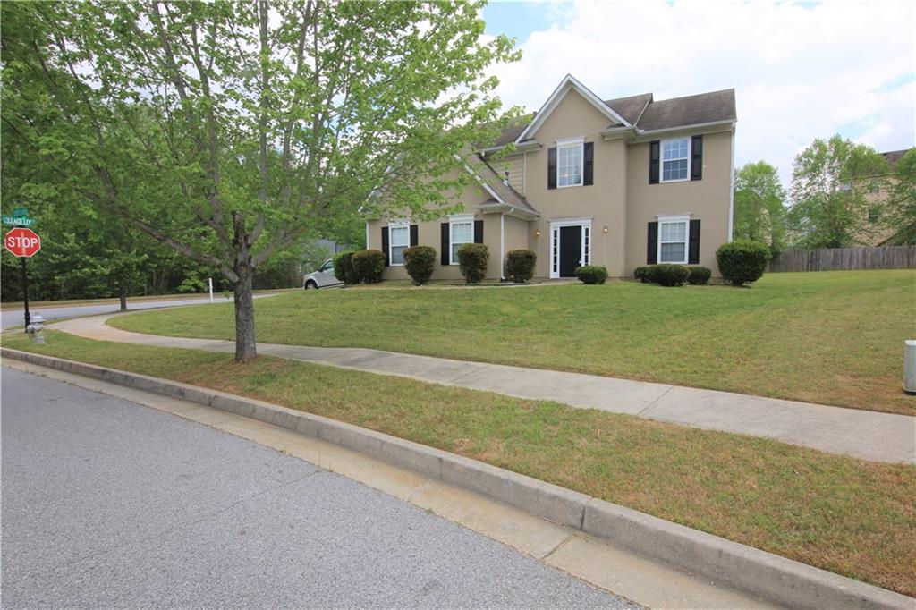 7628 Village Loop Fairburn, GA 30213 - Photo 1 of 1 a view of a house with a big yard and large trees