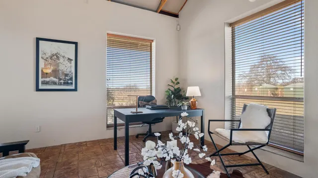 a view of a workspace with furniture and a window