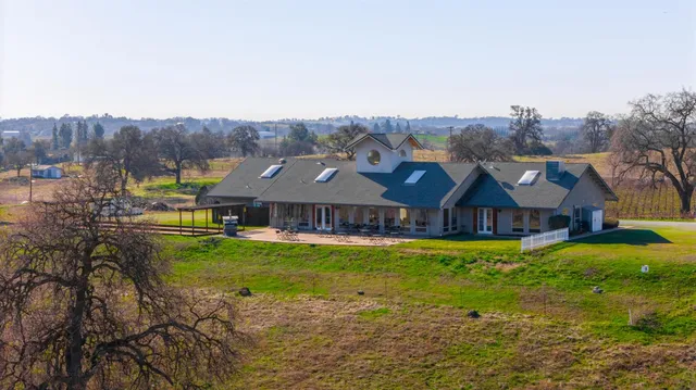 a view of a big house with a big yard and large tree