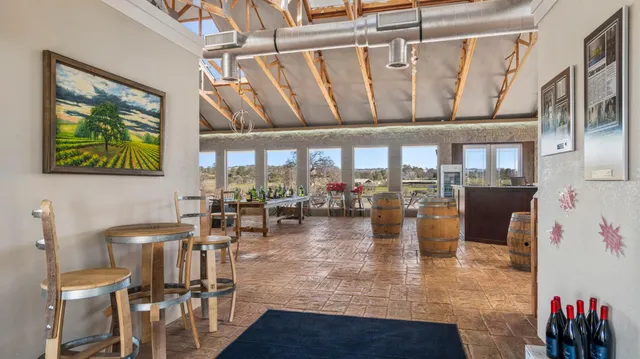 a view of a dining room with furniture one side kitchen view and wooden floor