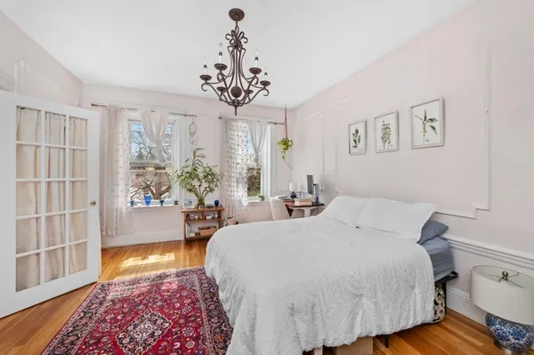 a bedroom with a large bed and a chandelier