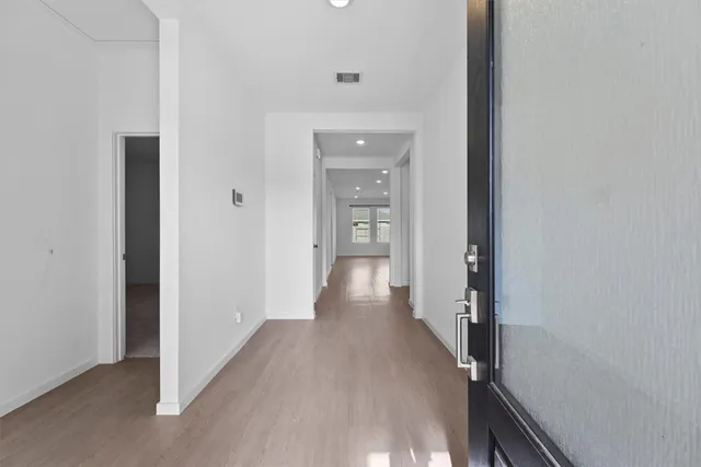 a view of a hallway with wooden floor