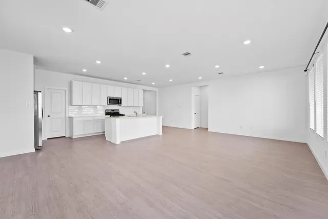 a view of kitchen with kitchen island and stainless steel appliances