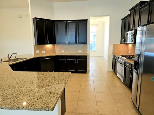 a kitchen with granite countertop a sink and a stove top oven