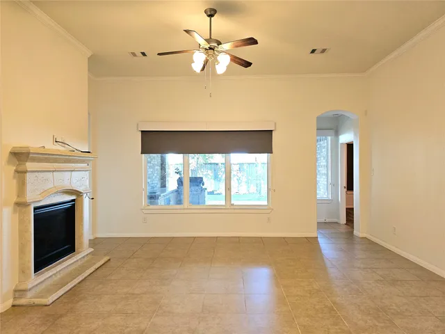 a view of an empty room with a fireplace and a window