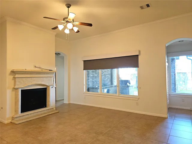 a view of an empty room with a fireplace and a window