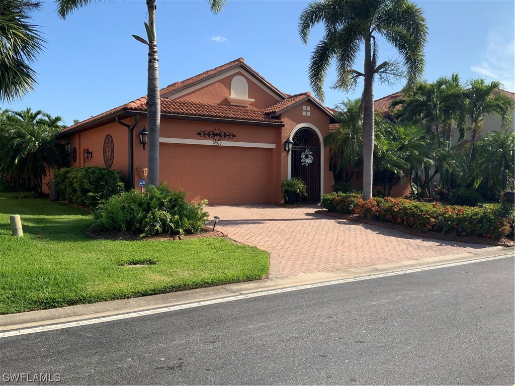 12918 Pastures Way Fort Myers, FL 33913 - Photo 3 of 34 a front view of a house with a yard and palm trees