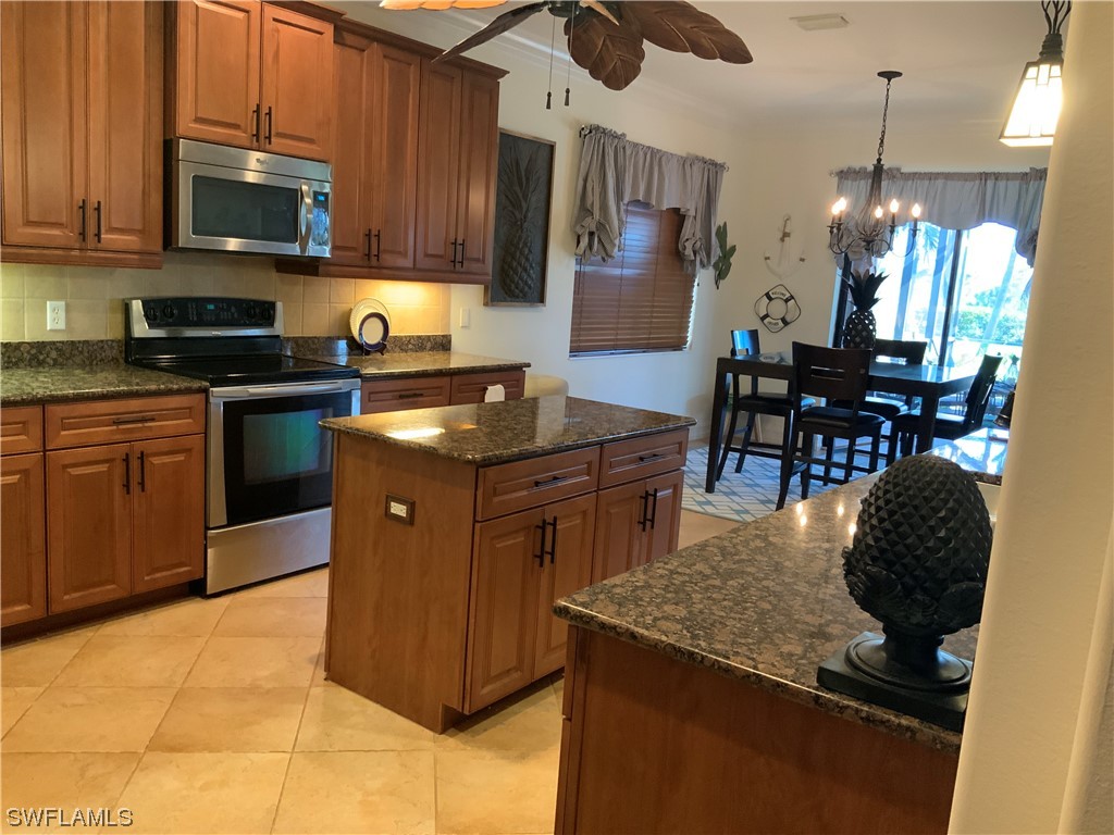 12918 Pastures Way Fort Myers, FL 33913 - Photo 7 of 34 a kitchen with granite countertop a stove a sink a microwave and a dining table