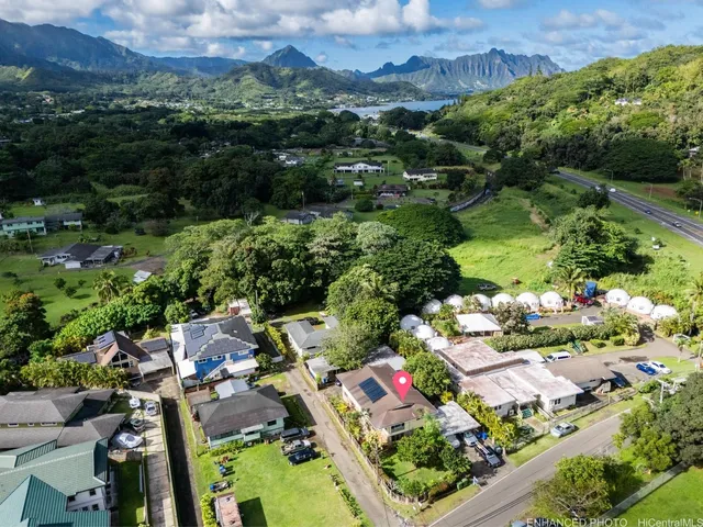 an aerial view of a houses with a yard and lake view